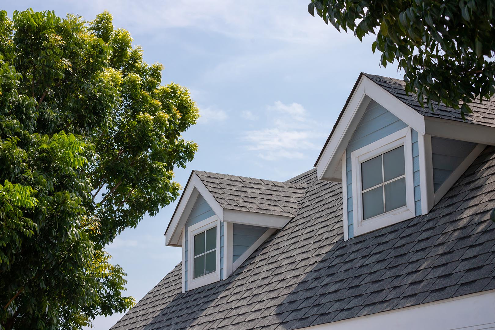 Roof shingles with garret house on top of the house among a lot Commercial Roofing Company in Fillmore, NY | Rabers Commercial Roofing